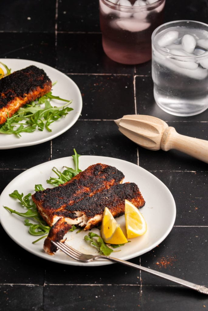 2 plates of blackened mahi mahi with a bite on a fork