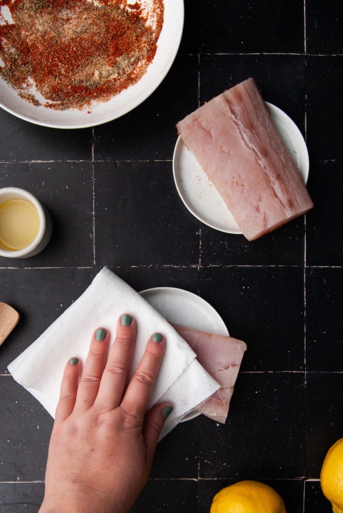 using paper towel to blot dry raw mahi mahi