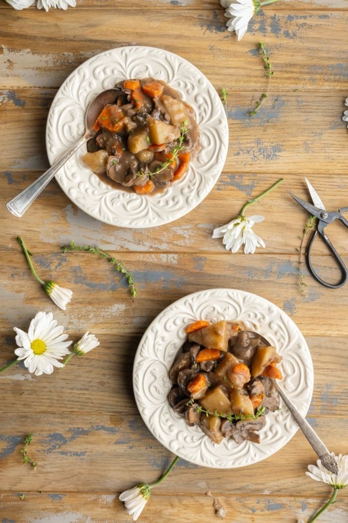 two little floral bowls with hearty mushrooms stew surrounded by flowers