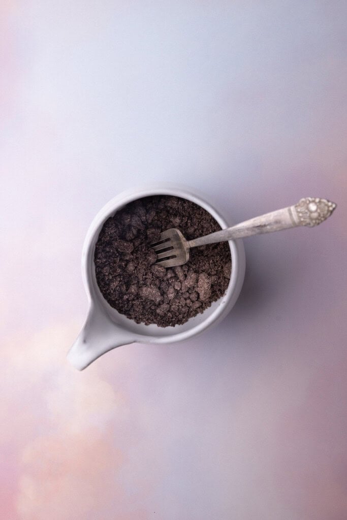 5 Oreos crushed by a fork inside a white mug.