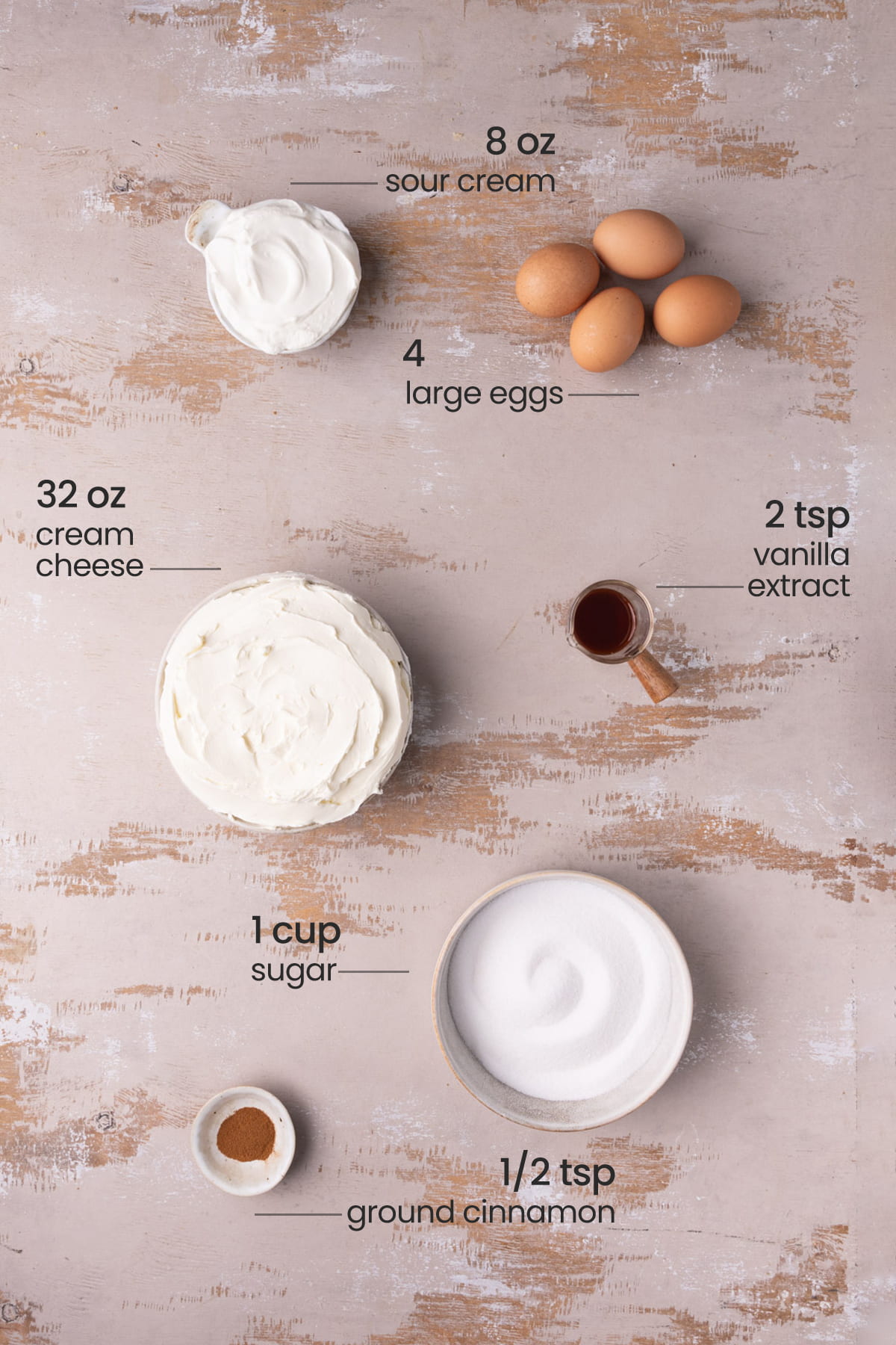 Ingredients for the filling of a Cinnamon Toast Crunch cheesecake layer - sour cream, large eggs, cream cheese, vanilla extract, sugar, cinnamon.