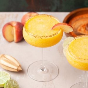 frozen cocktail garnished with a slice of peach