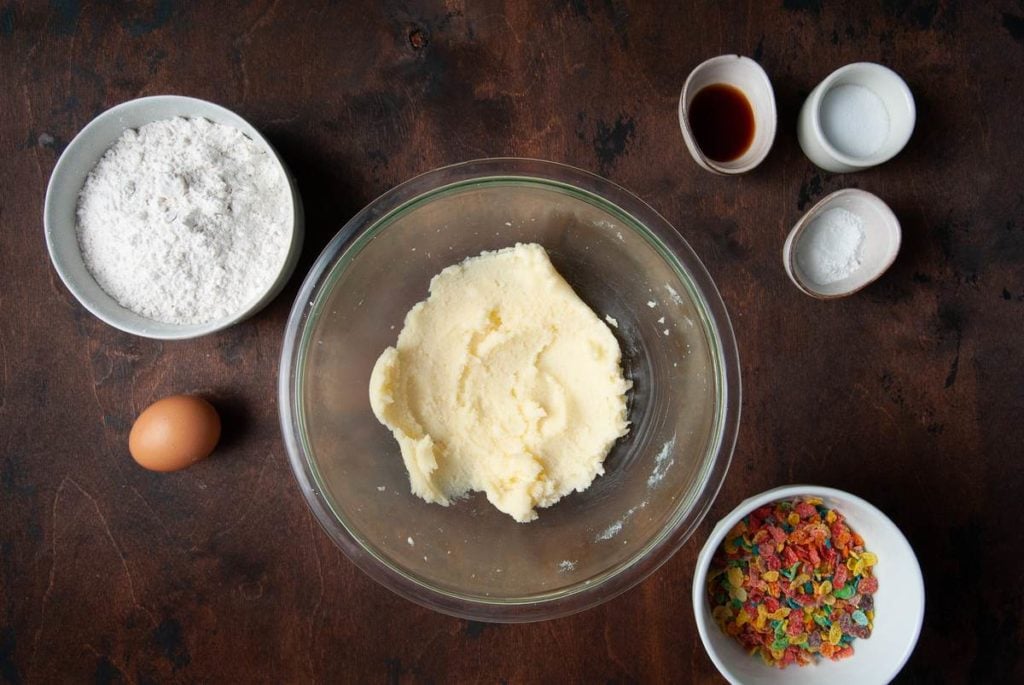 creamed butter and sugar in a bowl with other ingredients around it