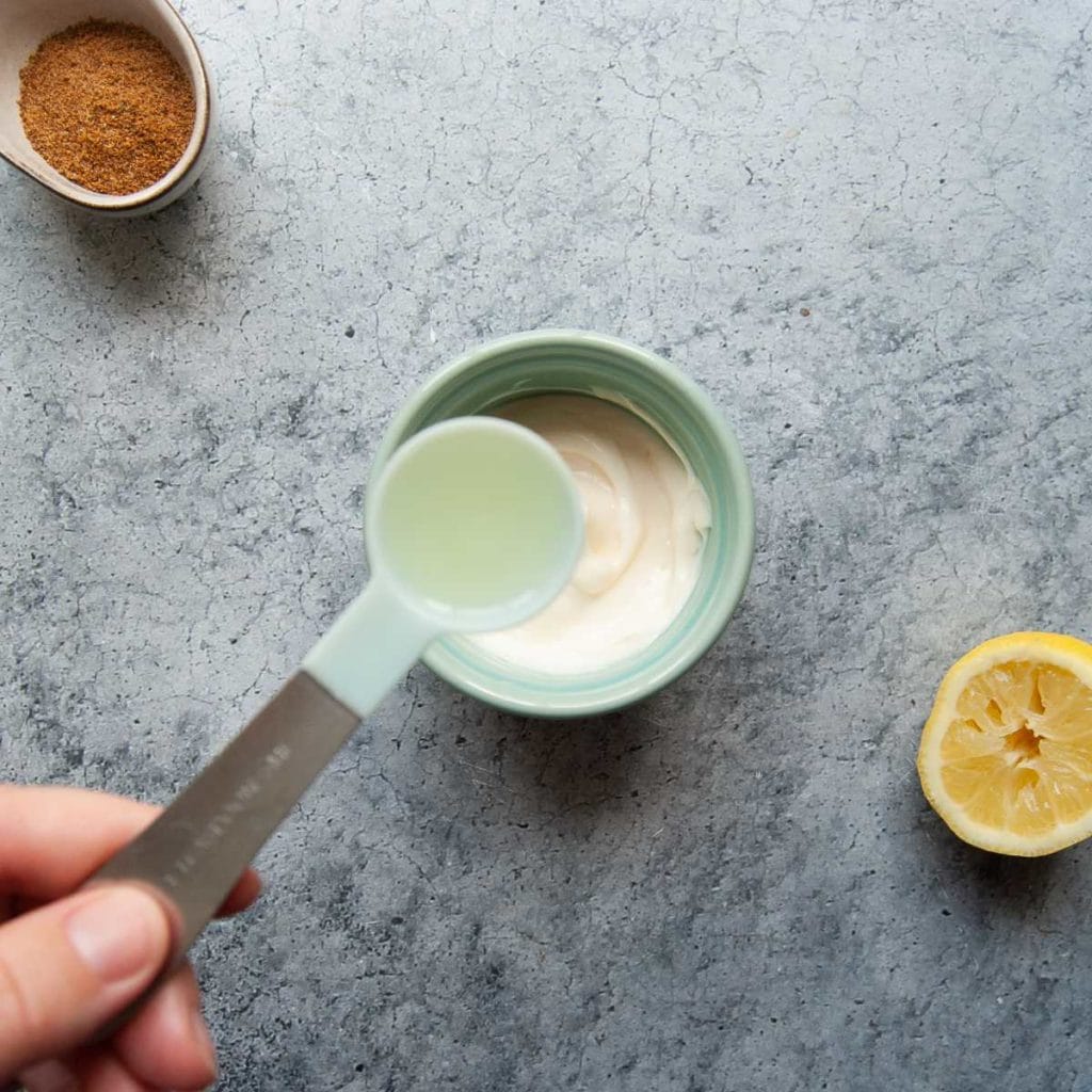 adding lemon to mayonnaise to make a quick aioli