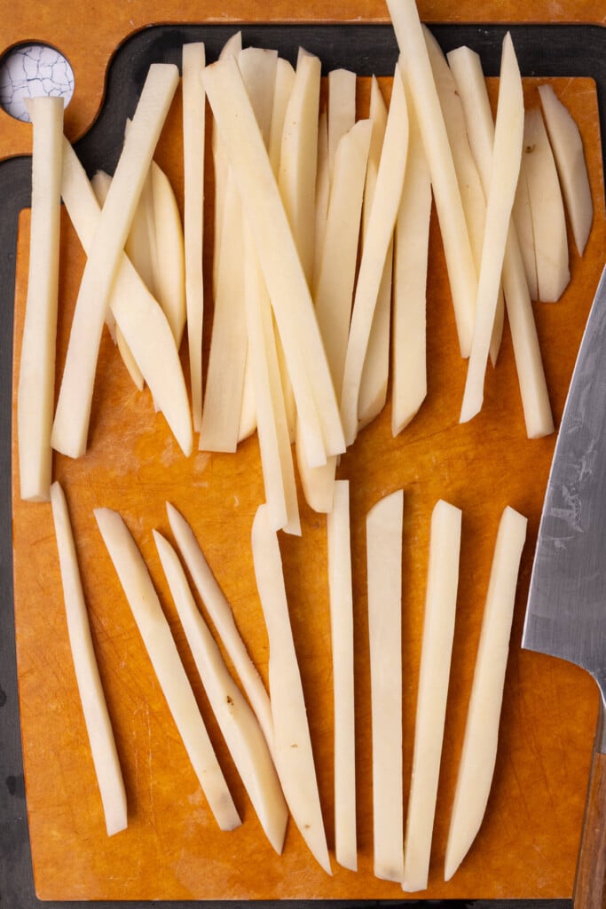 Hand cutting fries with a sharp knife.