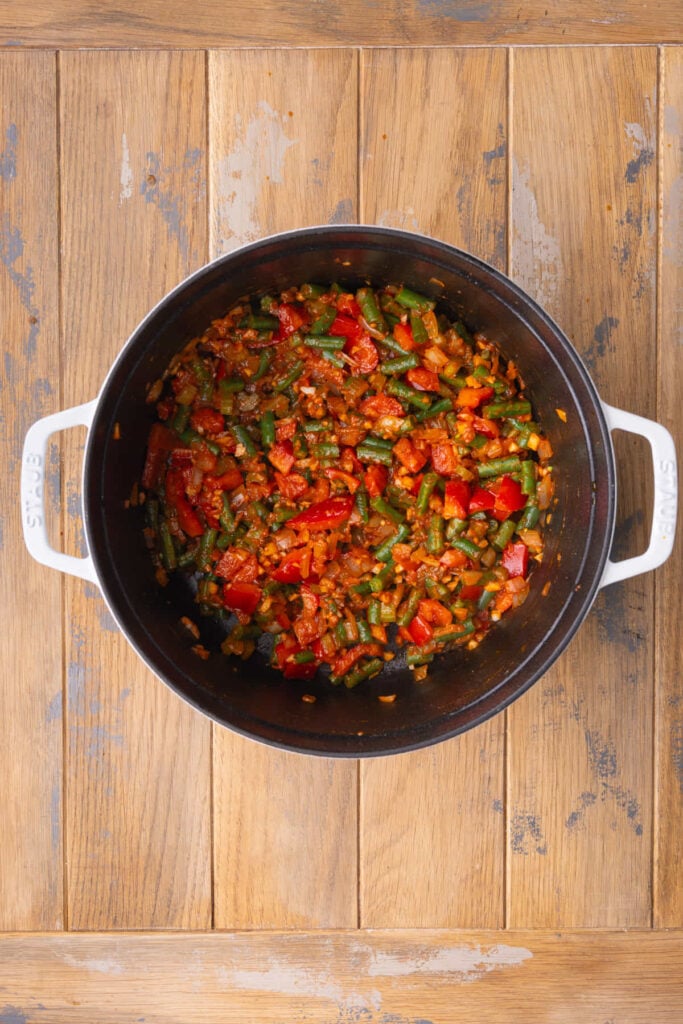 Green beans and red pepper cooking down in base of vegetarian soup.