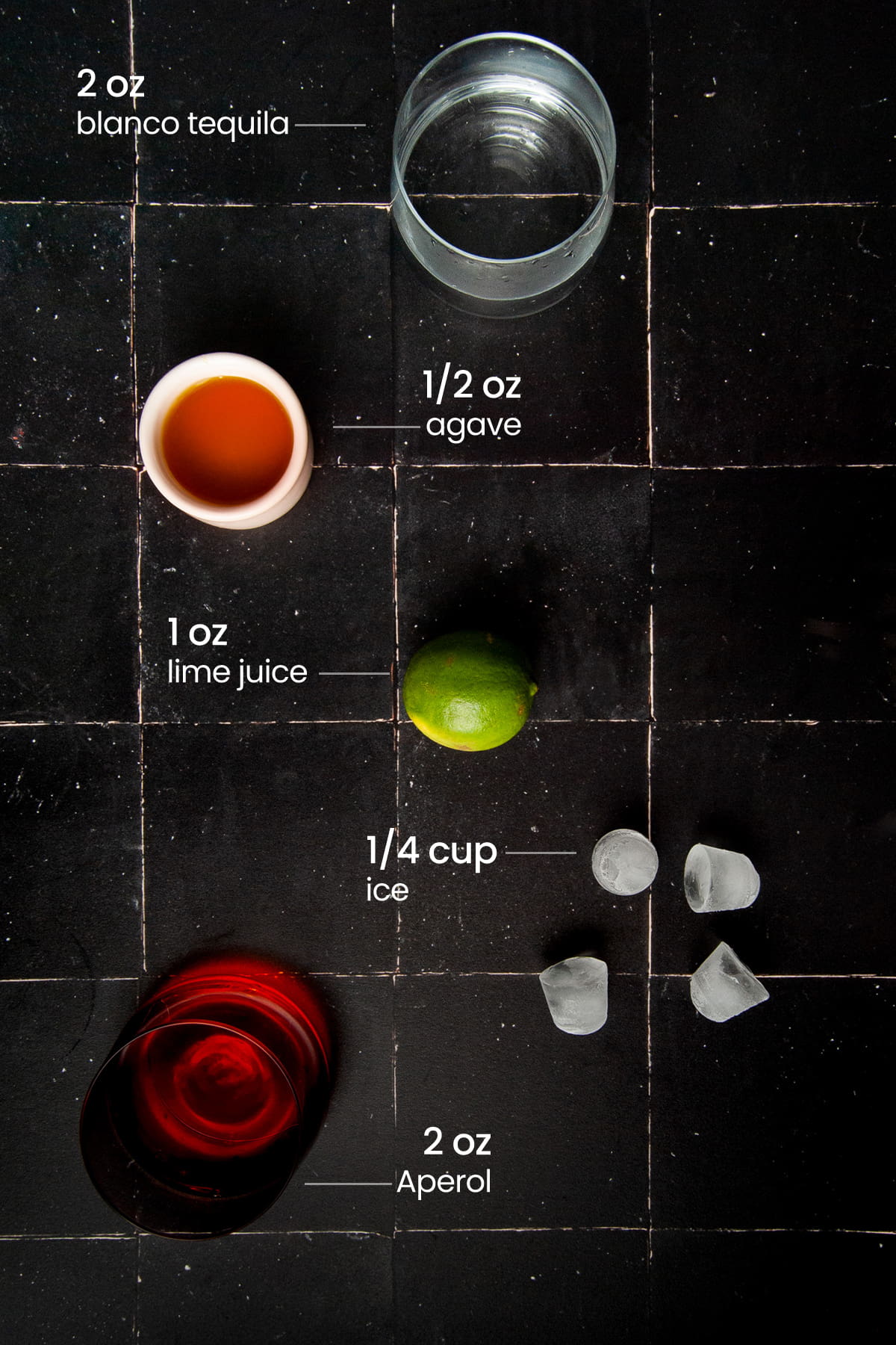 Overhead view of the ingredients needed for Aperol Margarita - tequila, agave nectar, lime, ice, and Aperol.