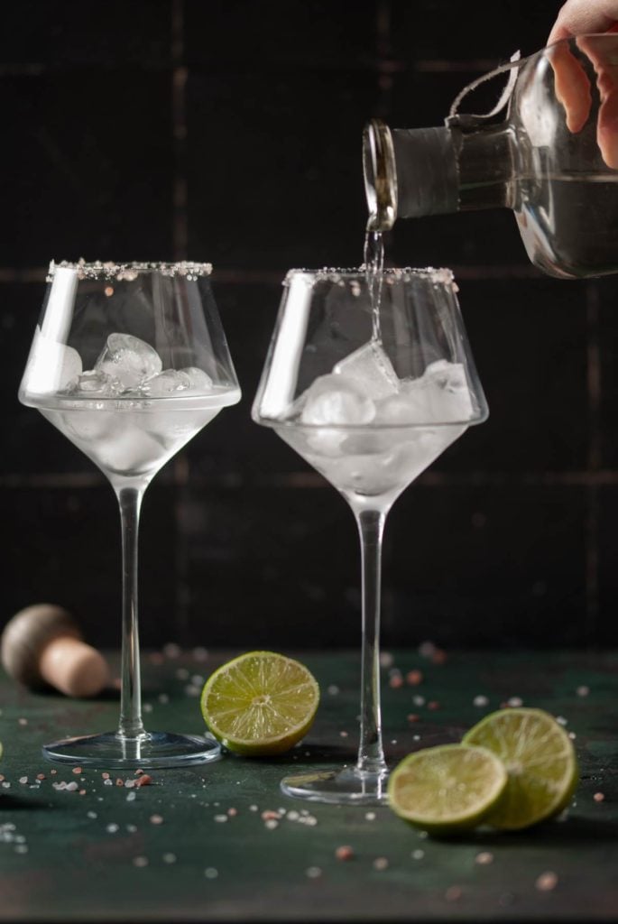 Pouring tequila into a wine glass with ice. 