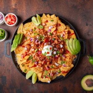 Overhead image of BBQ Jackfruit Nachos with sour cream, avocado and lime.