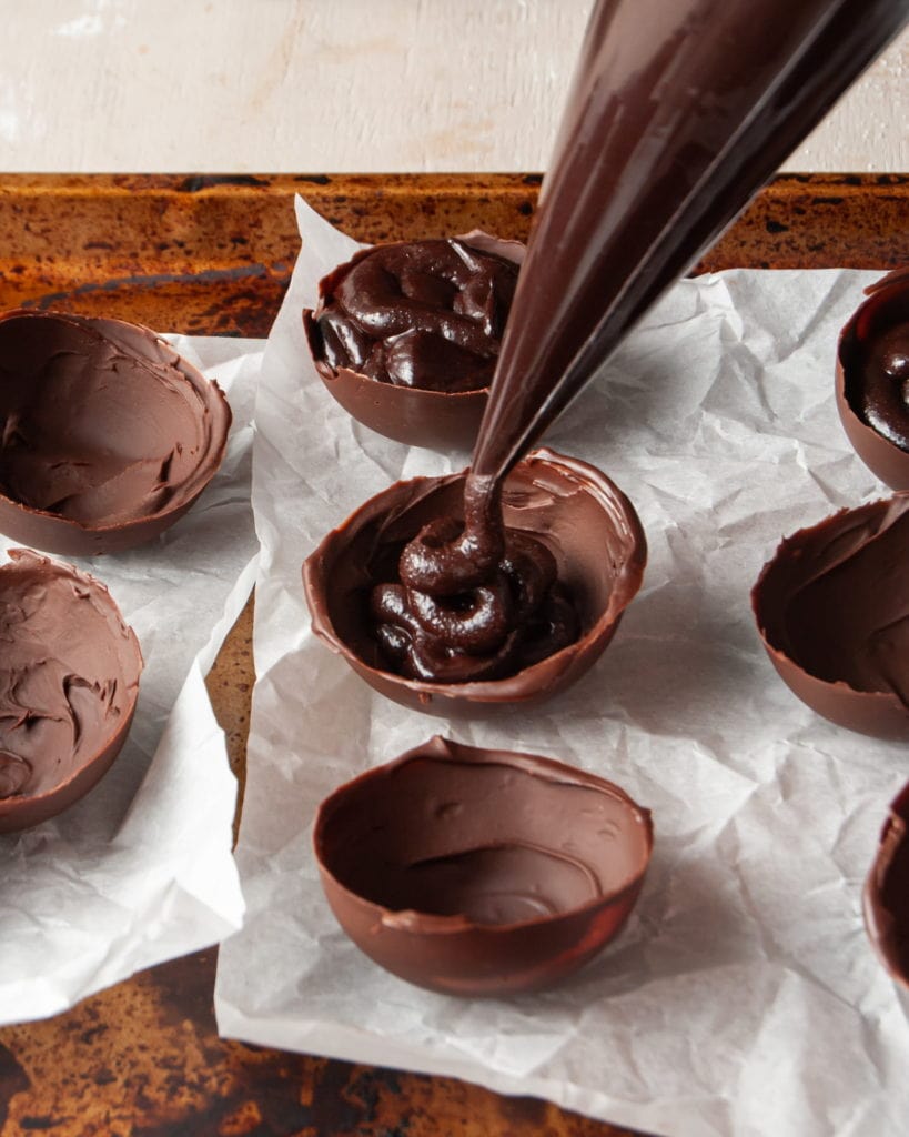 filling chocolate half-spheres with baileys hot chocolate bomb mixture