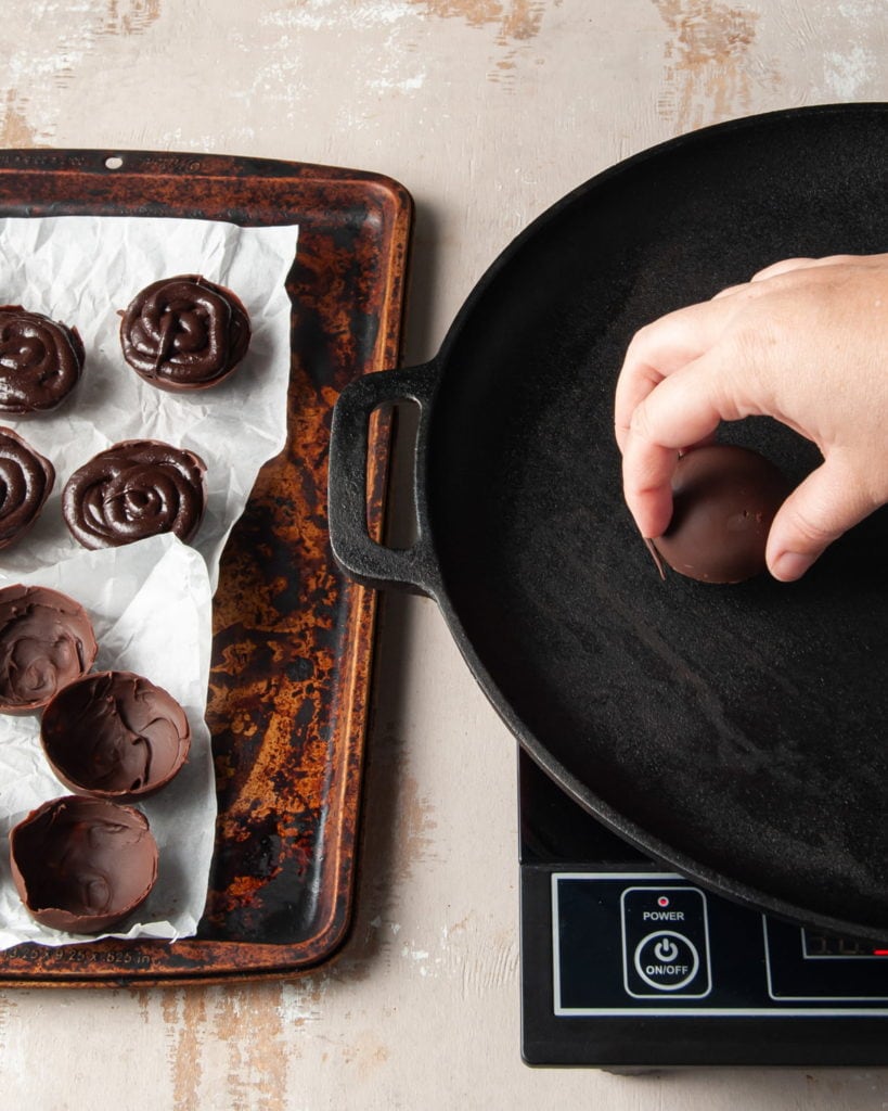 using a hot pan to melt the edges of a chocolate half sphere