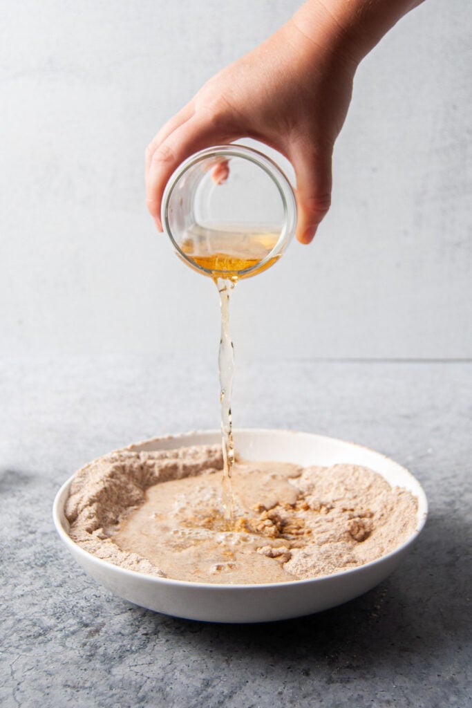 Pouring beer over flour and egg to form batter to fry fish in.
