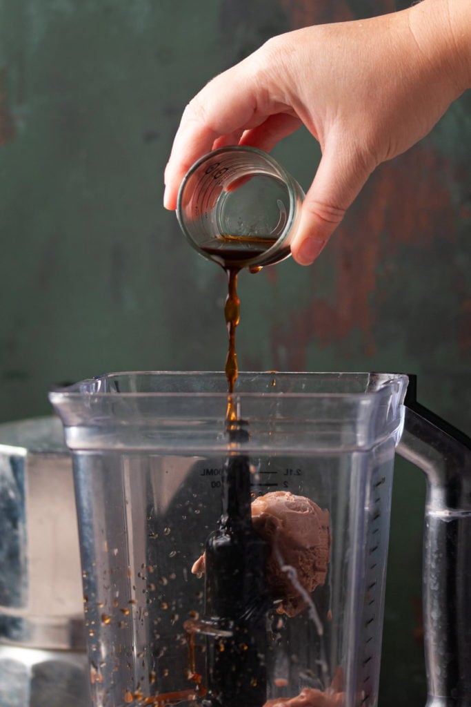 adding coffee to blender with ice cream