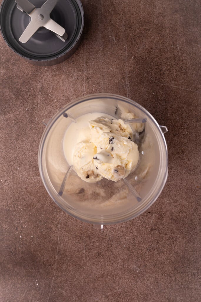Cookie dough ice cream and milk in a blender. 