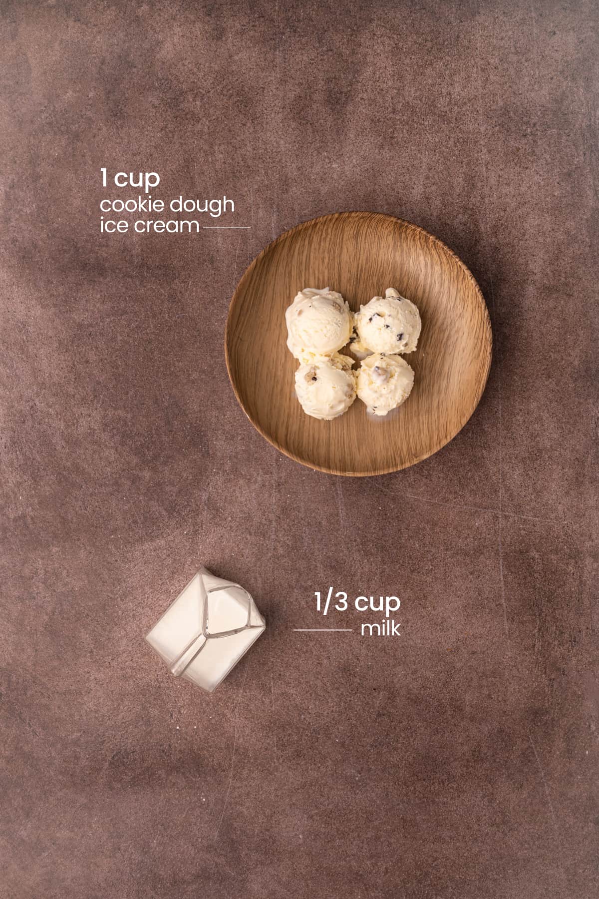 Overhead view of the ingredients for a cookie dough milkshake - cookie dough ice cream, and milk.