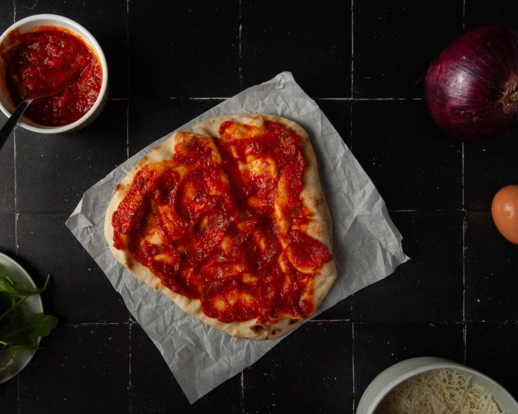 Adding Tomato Sauce to Naan Bread