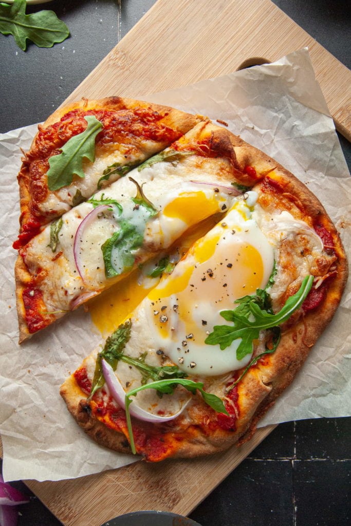 Slicing into Naan Breakfast Pizza with Yolk Oozing