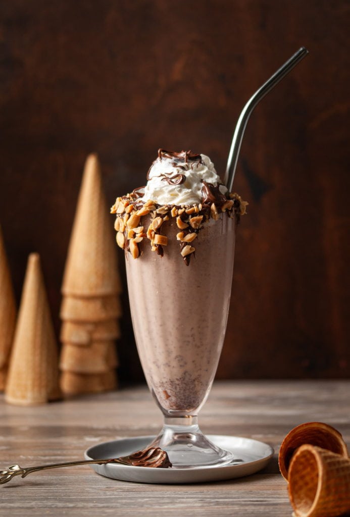 milkshake garnished with crushed hazelnuts with straw