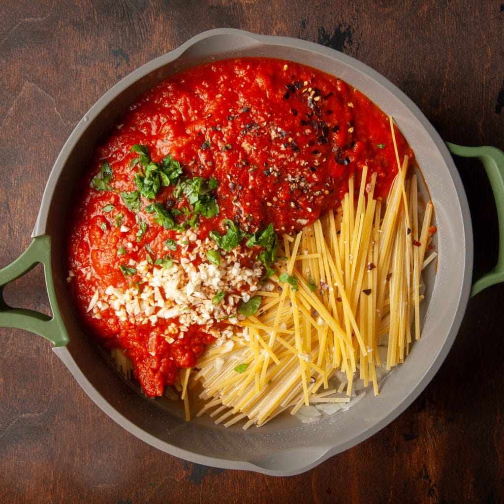 adding all the ingredients for on-pot vegan pasta into the saucepan