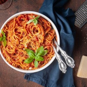 one-pot vegan pasta with tomato sauce next to parmesan cheese