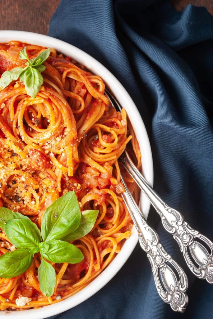 close up of pasta with tomato sauce and basil