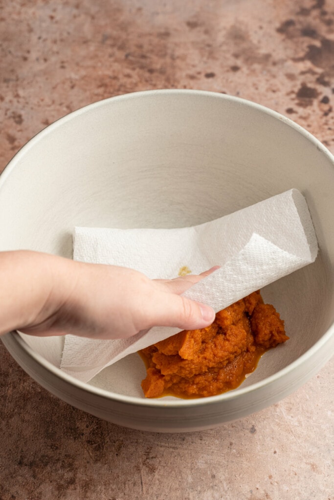 blotting pumpkin puree dry with a bamboo paper towel