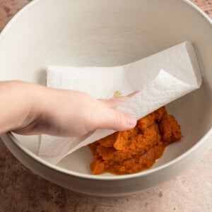 Using paper towel to remove excess moisture from pumpkin puree