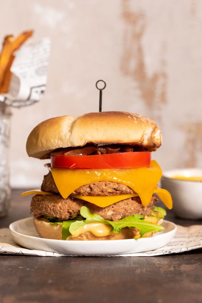 stacked meatless jackfruit burger stacked with greens and tomato and cheese