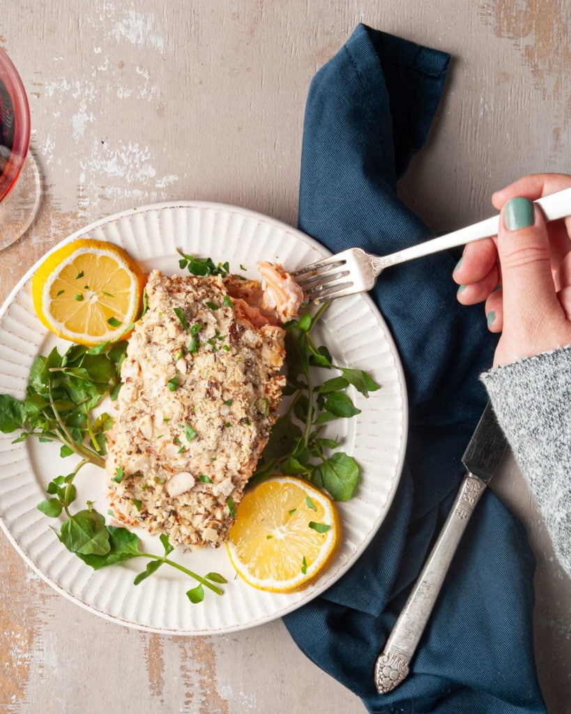 salmon dinner with hand holding forkful