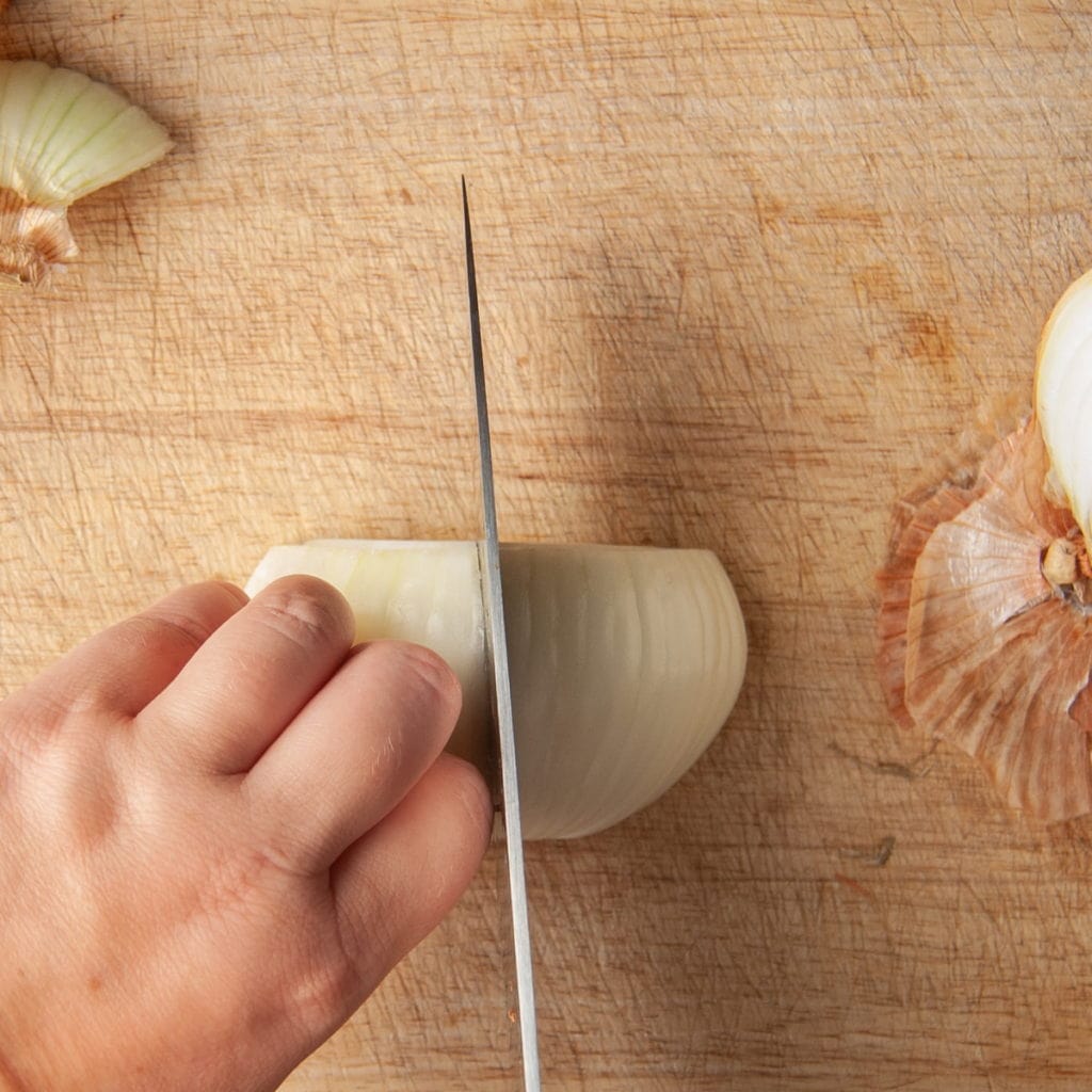 Slicing half of an onion into strips