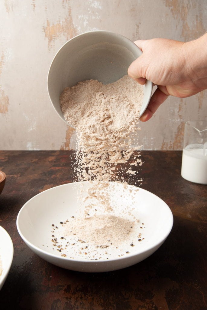 pouring flour into a bowl to make batter