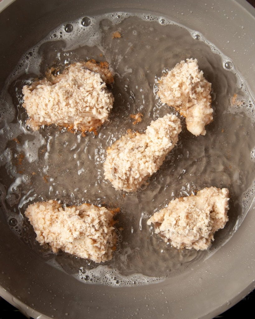 adding battered oyster mushrooms to hot oil