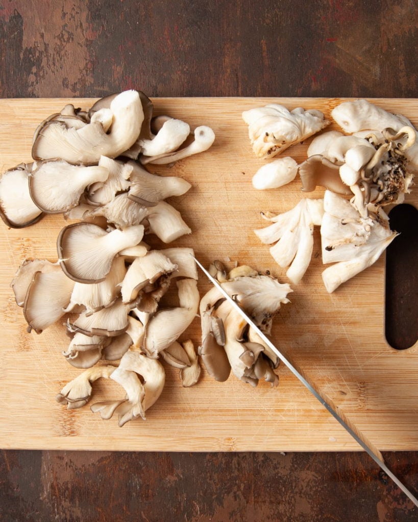 slicing oyster mushrooms off of the central stem