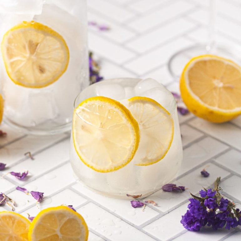 3 Vodka Sours in different glasses garnished with fresh lemon