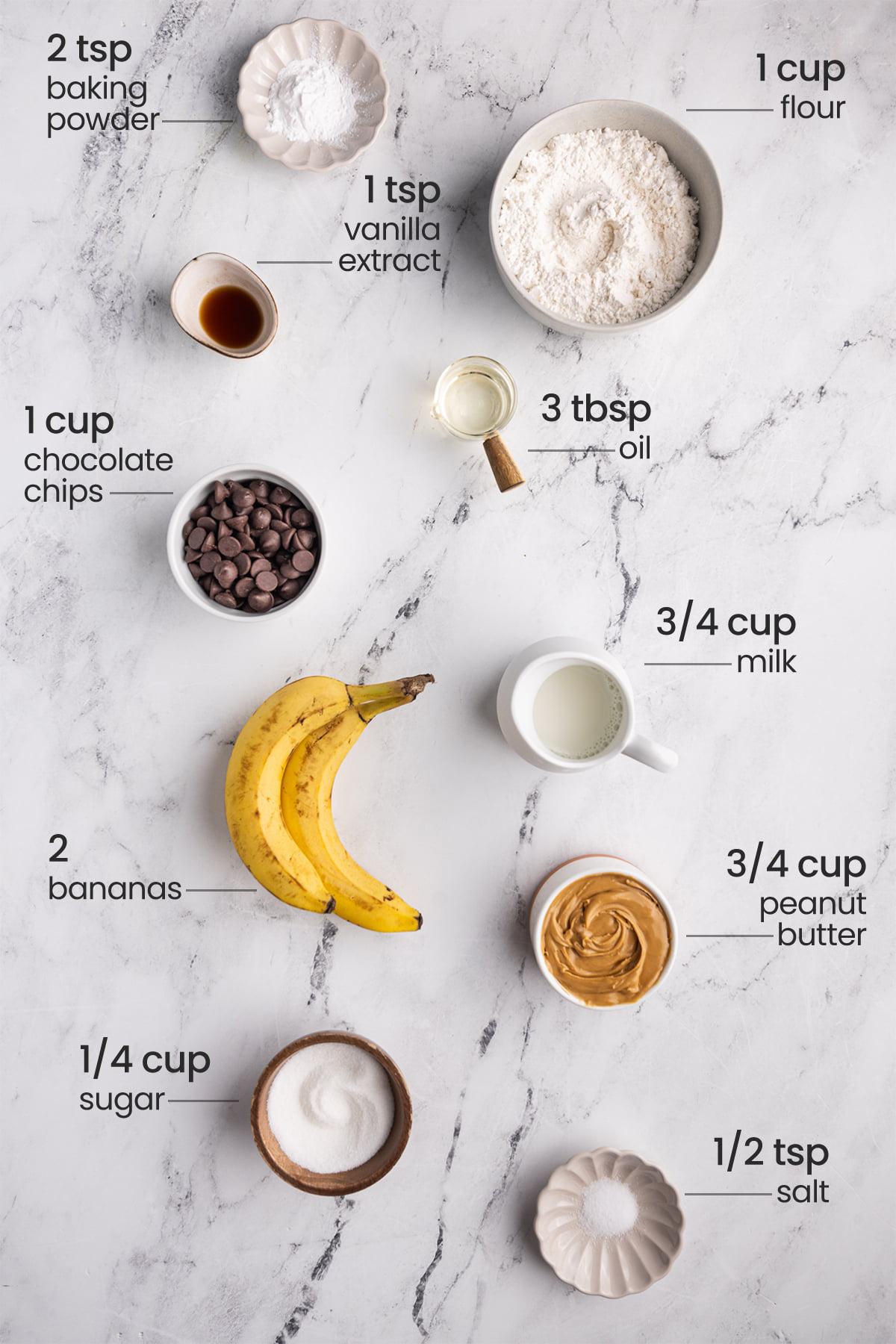 ingredients for peanut butter banana chocolate chip muffins - baking powder, flour, vanilla extract, chocolate chips, oil, milk, bananas, peanut butter, sugar, salt