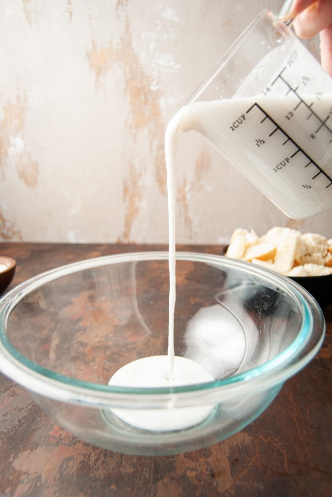 Adding coconut milk to mixing bowl.