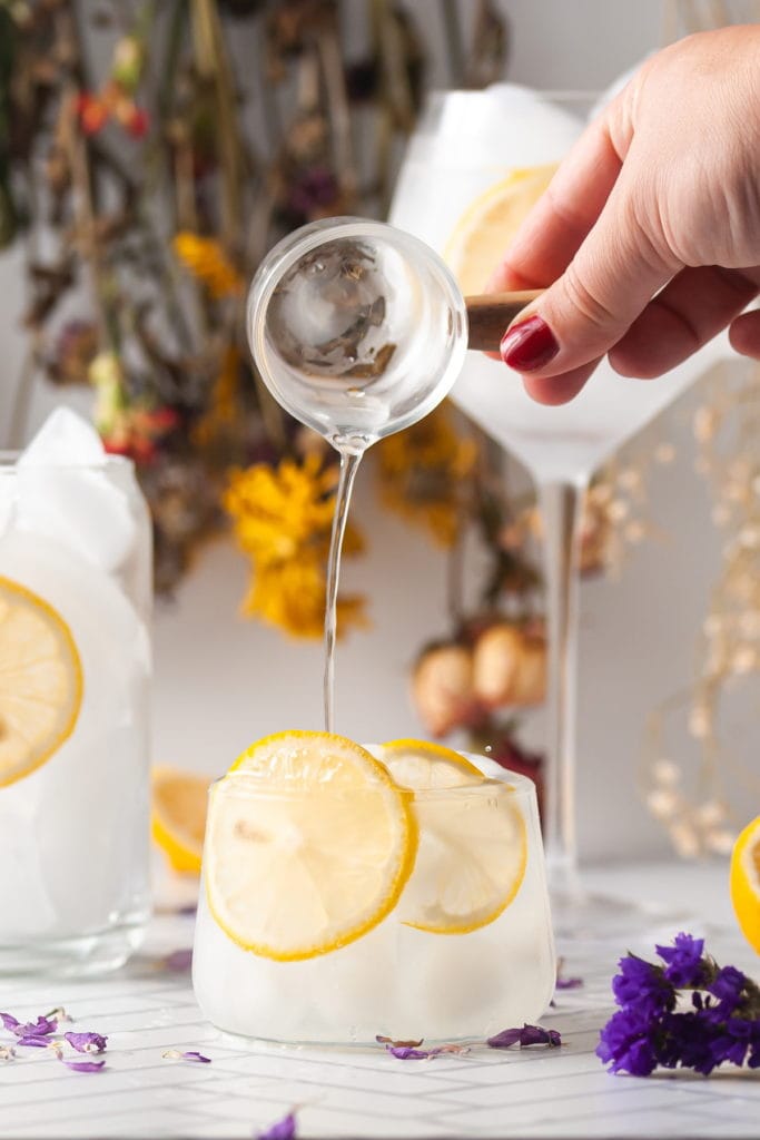 pouring simple syrup into refreshing cocktail