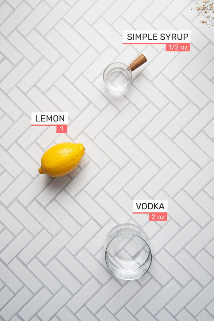ingredients for vodka sour - simple syrup, lemon, and vodka