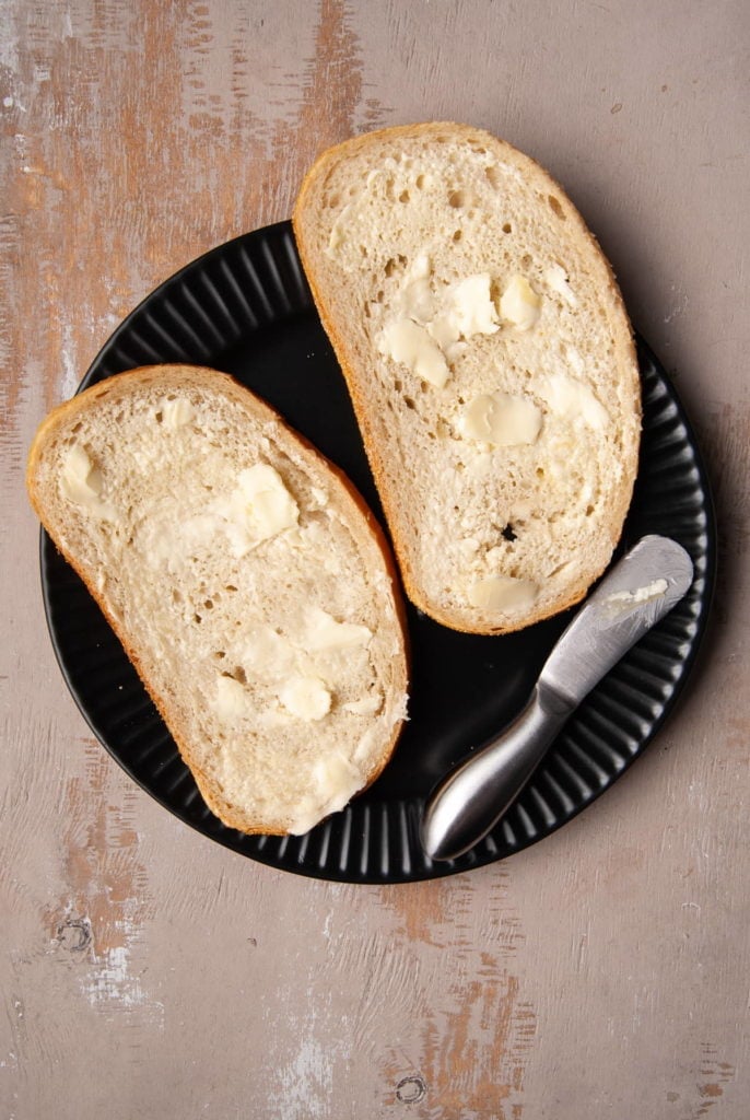 Butter spread on one side of two slices of bread.