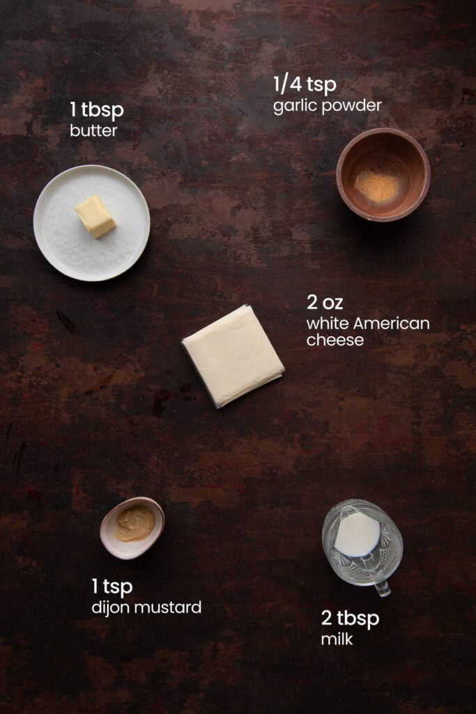 Everything you need to make the cheese sauce for a vegetarian Philly Cheesesteak including white American cheese, milk, Dijon mustard, butter, and garlic powder.