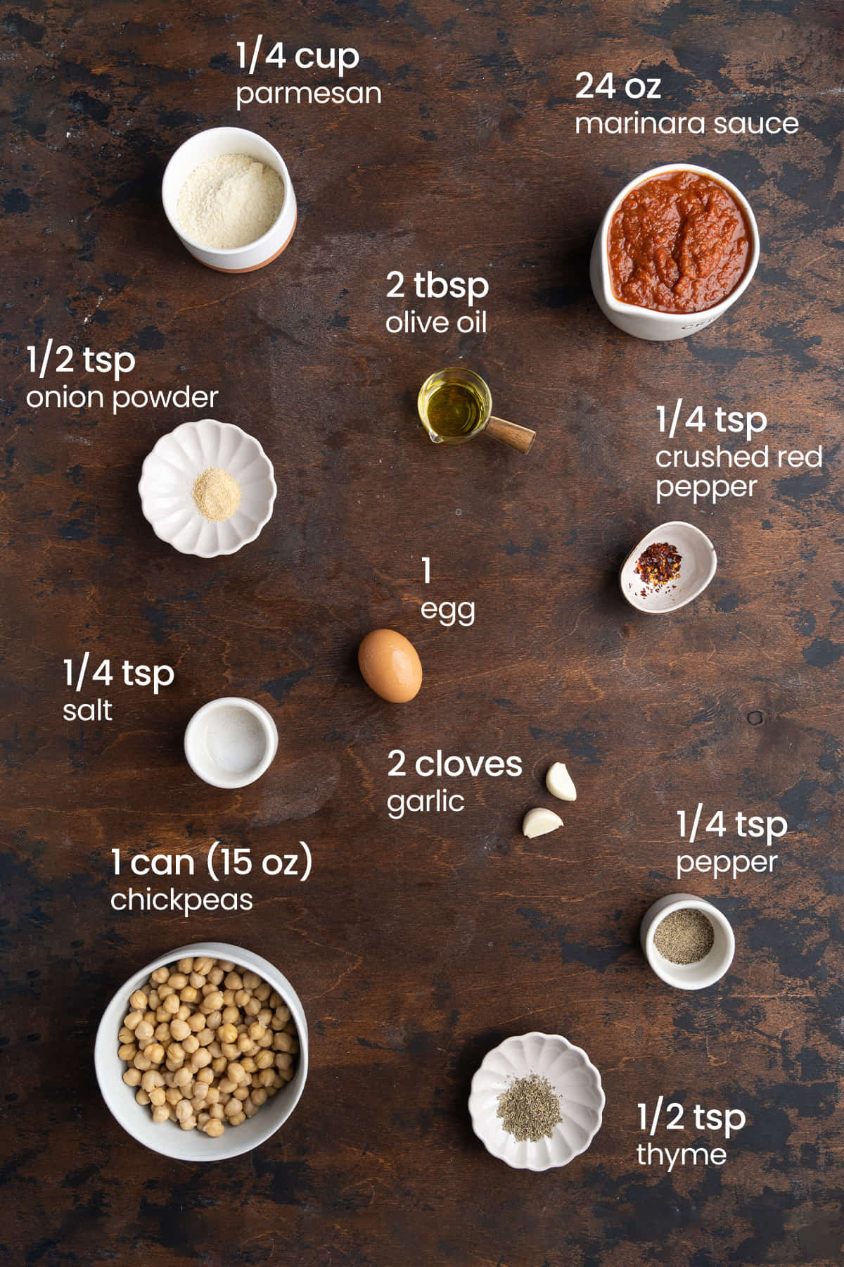 Everything to make chickpea meatballs including Parmesan cheese, marinara, olive oil, onion powder, crushed red pepper, an egg, salt, pepper, garlic, thyme, and chickpeas.