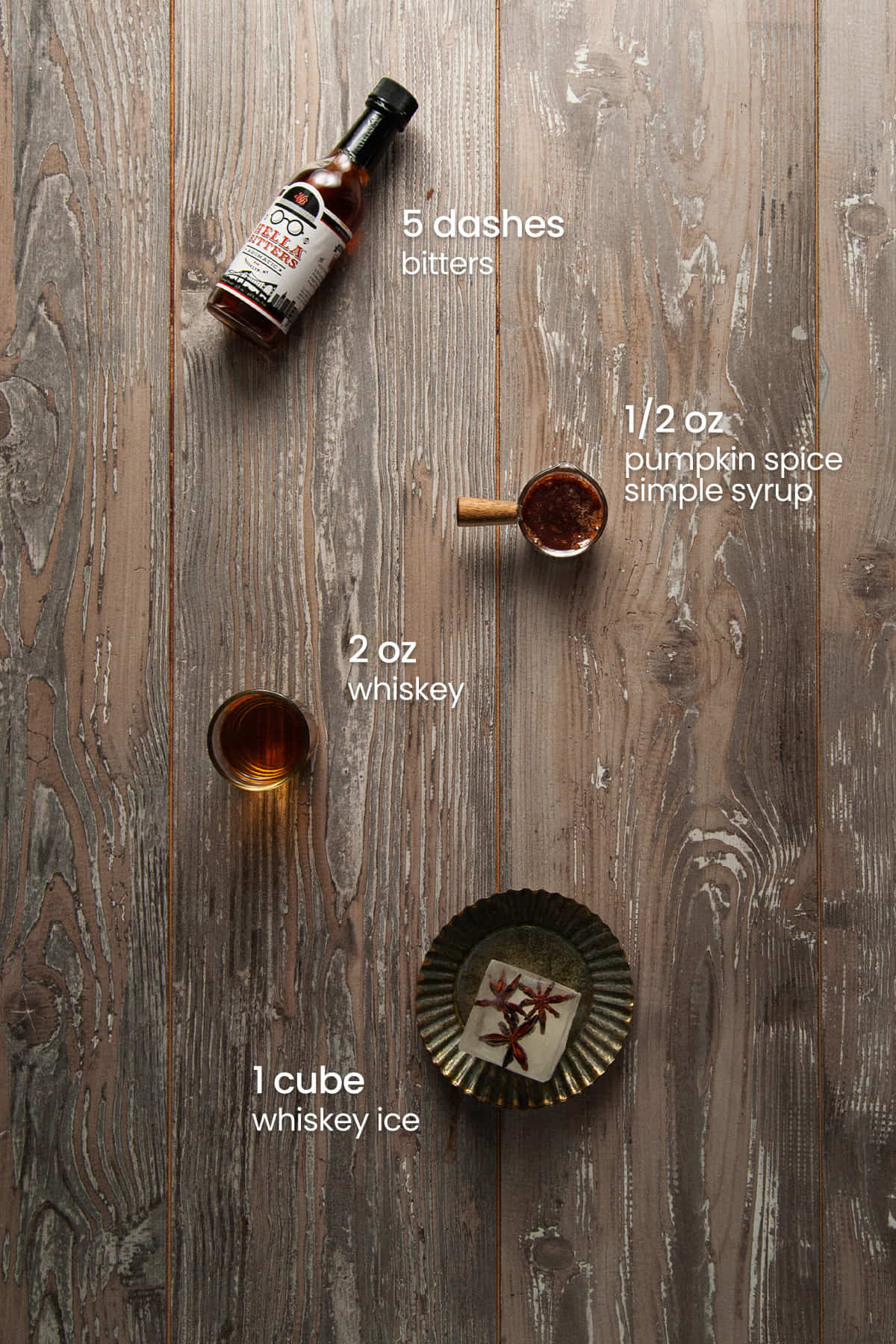 Everything you need to make a Pumpkin Spice Old Fashioned including aromatic bitters, pumpkin spice simple syrup, bourbon and whiskey ice.