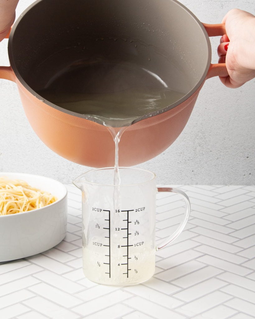 pouring pasta water into measuring cup