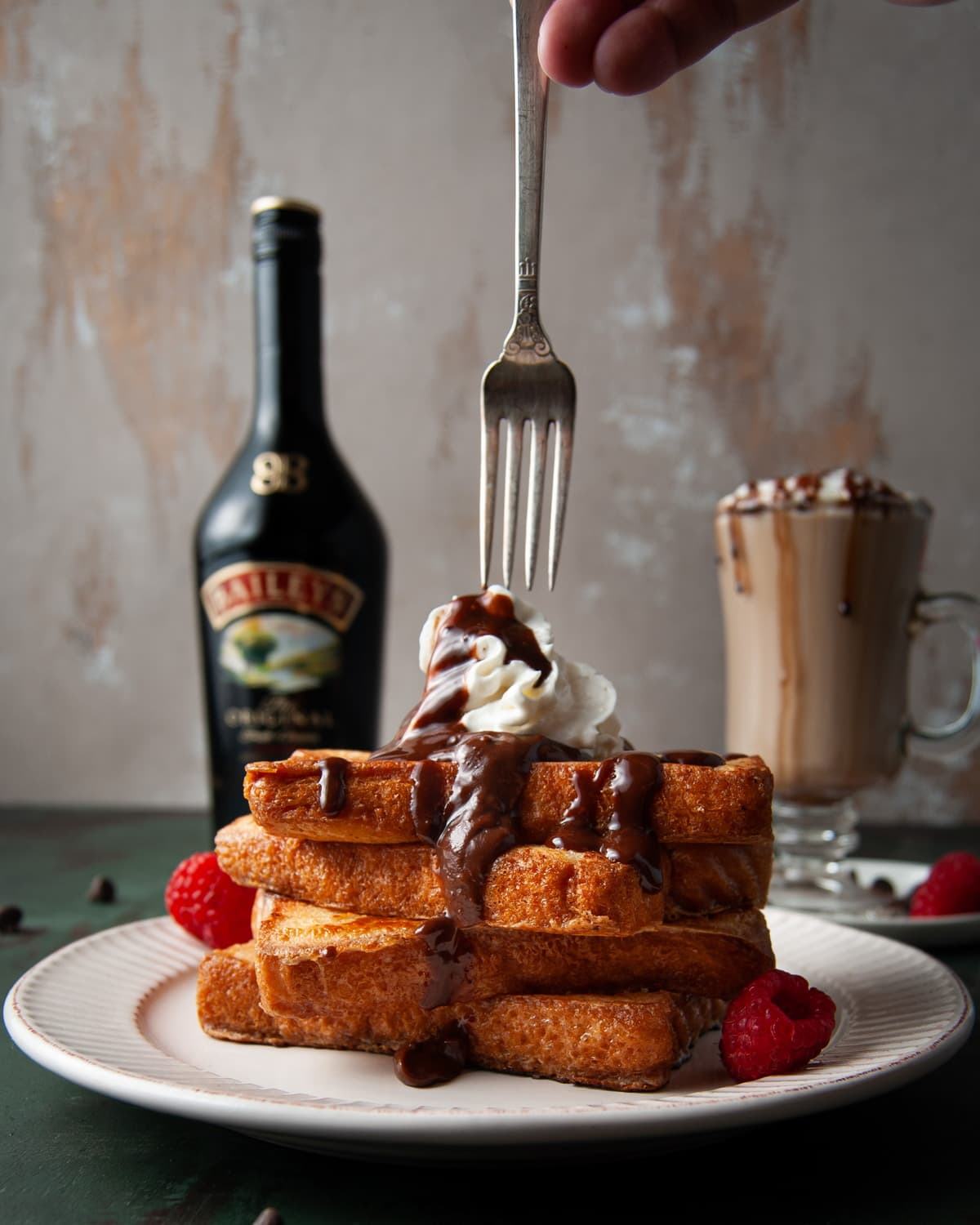 taking a fork to a stack of French Toast covered in chocolate