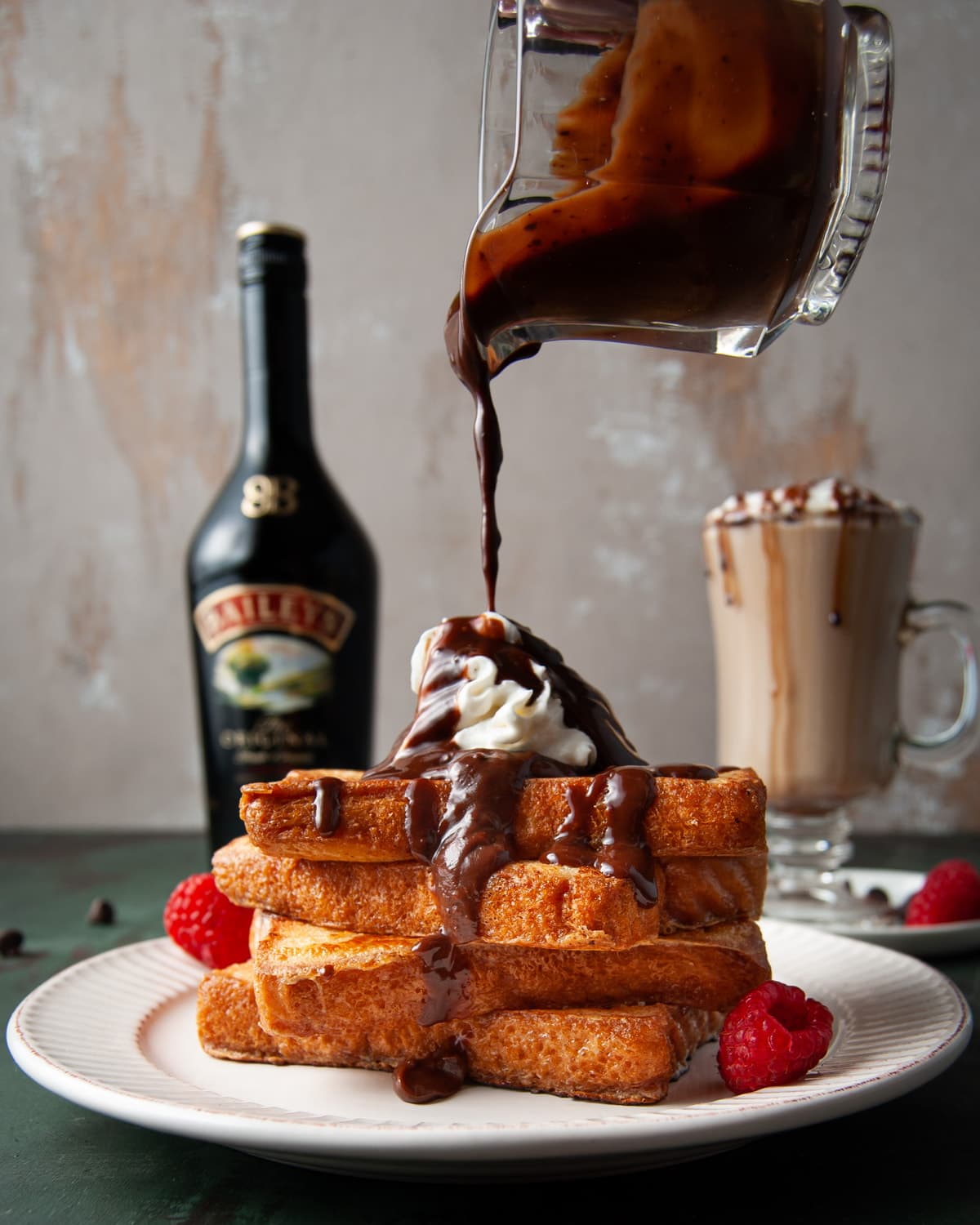 pouring Bailey's chocolate sauce over Bailey's french toast