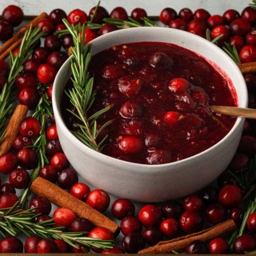 brandy cranberry sauce with gold spoon and garnished with rosemary