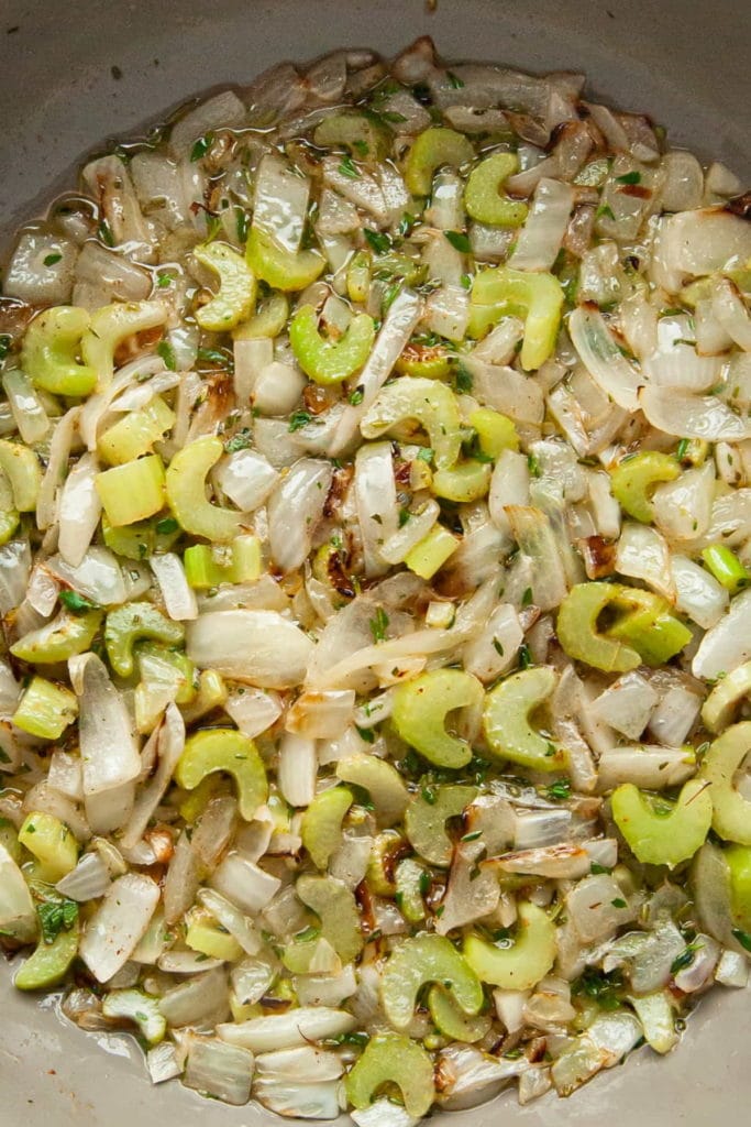 sauteeing celery, onions, thyme, and rosemary in butter in a frying pan