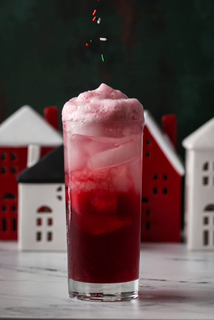 adding sprinkles ontop of foam in christmassy drink