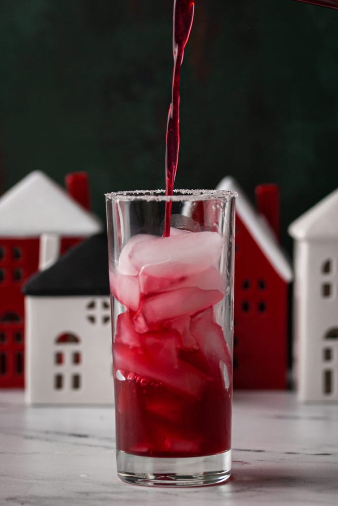straining gin and cranberry christmas  cocktail