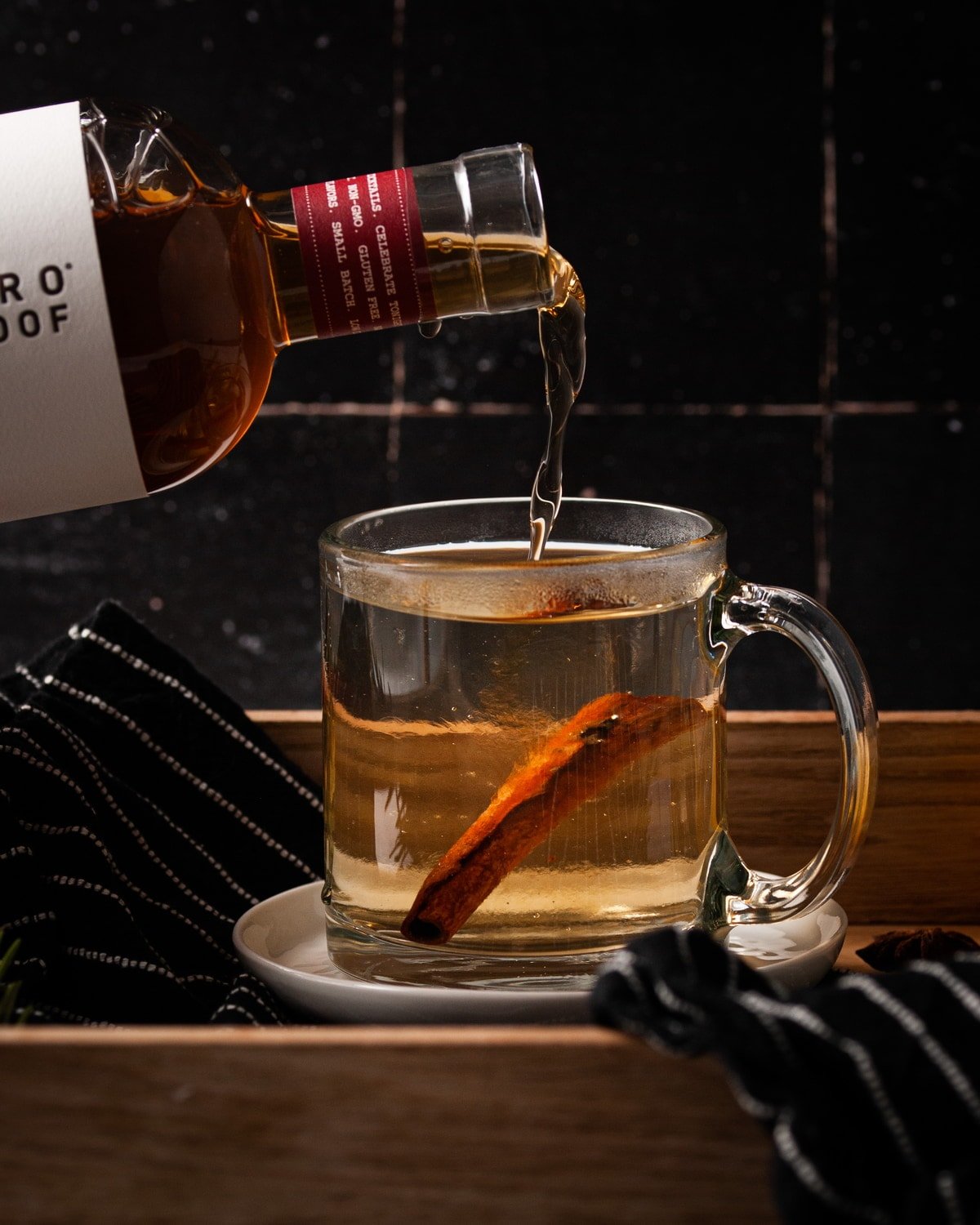 adding whiskey alternative to hot water and cinnamon stick